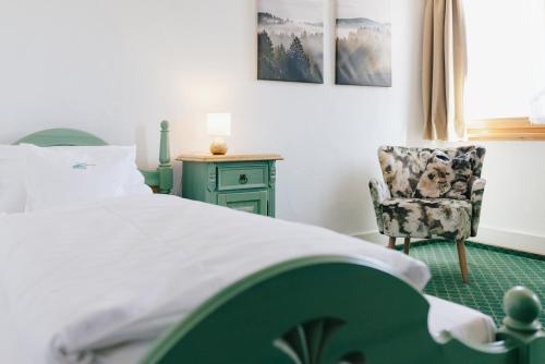 a bedroom with a bed and a chair at Gasthaus Zum Kreuz in Sankt Märgen