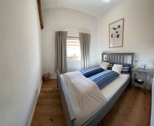 a bedroom with a bed with blue pillows and a window at Charmantes Luxus Maisonette- Apartement in Bad Hersfeld