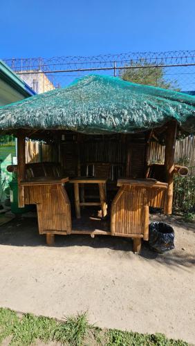 a hut with a green tarp on top of it at Natural Haven with Netflix Kubo Videoke & Alfresco Dining in Dasmariñas