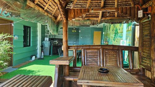 a patio with a wooden bench and a kitchen at Natural Haven with Netflix Kubo Videoke & Alfresco Dining in Dasmariñas