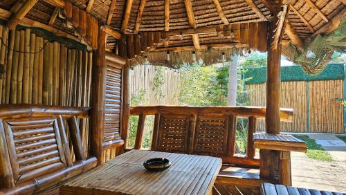 a room with a wooden table in a hut at Natural Haven with Netflix Kubo Videoke & Alfresco Dining in Dasmariñas