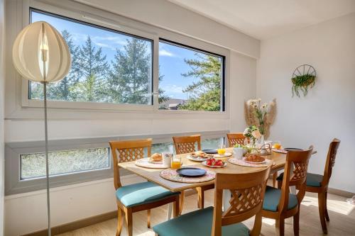 une salle à manger avec une table, des chaises et des fenêtres dans l'établissement Le havre de Paix - Near Geneva - Calm and Quiet, à Ferney-Voltaire