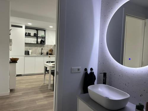 a bathroom with a white sink and a mirror at Apartamento palafrugell parking y wifi gratis in Palafrugell