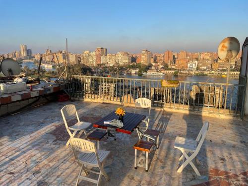 a patio with a table and chairs on a balcony at Nile and island in Cairo