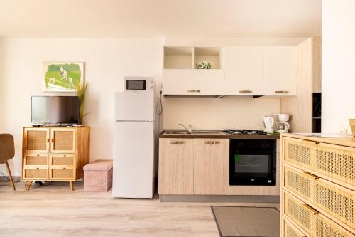 Il comprend une cuisine équipée d'un réfrigérateur blanc et d'une cuisinière. dans l'établissement NAUSICAA - Cosy studio with terrace, à Menton