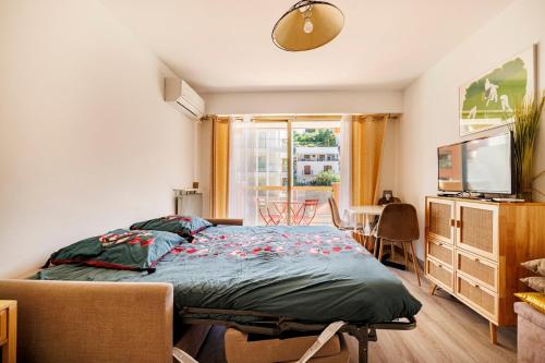 une chambre avec un lit et une télévision dans l'établissement NAUSICAA - Cosy studio with terrace, à Menton