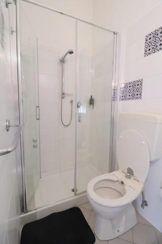 a white bathroom with a shower and a toilet at Fasthotel in Cervia