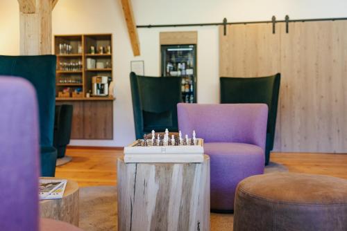 a room with purple chairs and a chess board on a table at Gasthaus Zum Kreuz in Sankt Märgen