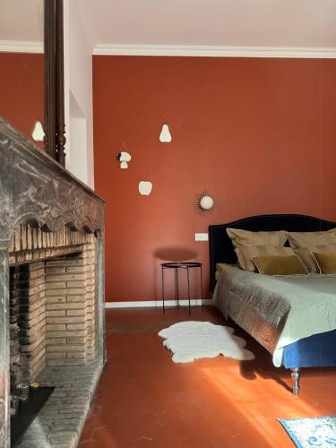 une chambre avec un lit et une cheminée dans l'établissement Location studio vacances dans Chateau, à La Celle-sous-Gouzon