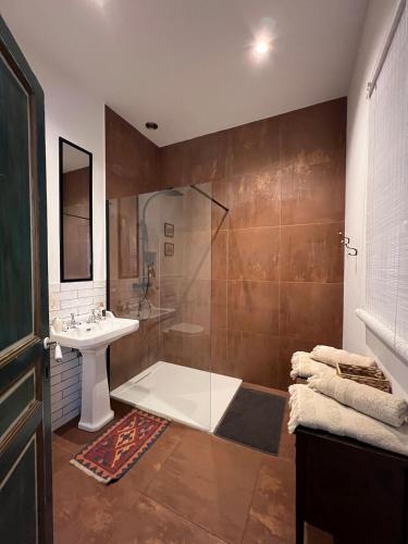 une salle de bain avec une douche en verre et un lavabo dans l'établissement Location studio vacances dans Chateau, à La Celle-sous-Gouzon