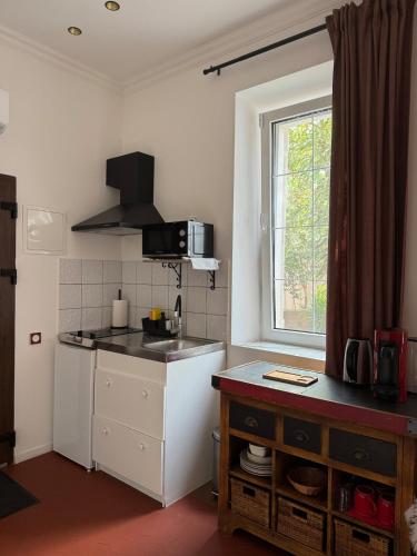 une cuisine avec un évier et un plan de travail dans l'établissement Location studio vacances dans Chateau, à La Celle-sous-Gouzon