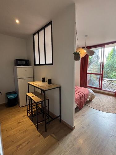 Cette chambre comprend une table, un lit et une cuisine. dans l'établissement Studio équipé Clim jardin Spa Centre Arles à 10mn, à Arles