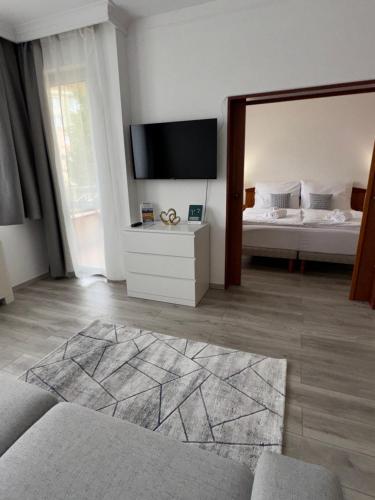 a living room with a bed and a large mirror at Goldvilla Apartman in Zalakaros