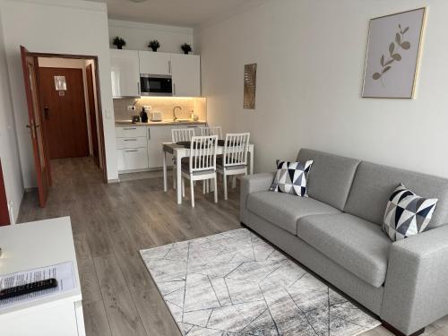 a living room with a couch and a kitchen at Goldvilla Apartman in Zalakaros