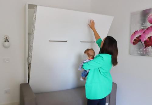 a woman and a child painting a wall at Valeria Apartment in Monza
