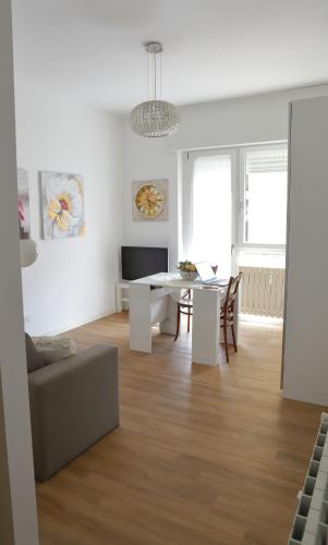 a white living room with a table and a couch at Valeria Apartment in Monza