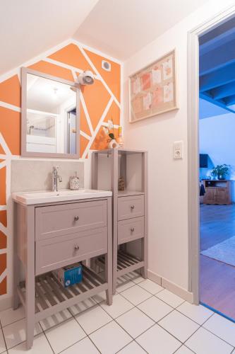 une salle de bain avec un lavabo et un miroir dans l'établissement Escale du mont, à Pontorson