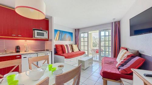 une cuisine et un salon avec une table et un canapé dans l'établissement M-Albatros 01-Moliets Appartement 4- 5 personnes proche golf dans résidence avec piscines, à Moliets-et-Maa