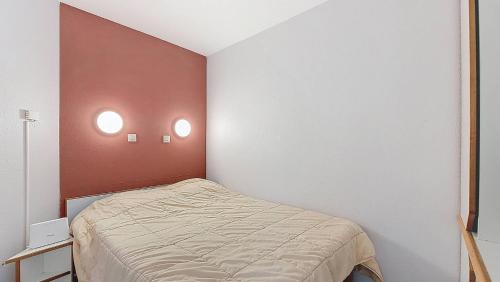- une petite chambre avec un lit et deux lumières sur le mur dans l'établissement M-Albatros 01-Moliets Appartement 4- 5 personnes proche golf dans résidence avec piscines, à Moliets-et-Maa
