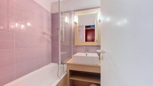 La salle de bains rose est pourvue d'un lavabo et d'une baignoire. dans l'établissement M-Albatros 01-Moliets Appartement 4- 5 personnes proche golf dans résidence avec piscines, à Moliets-et-Maa