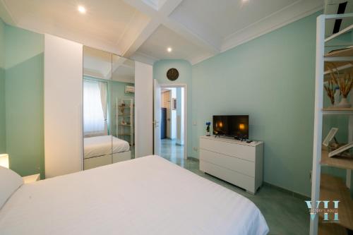 a bedroom with a white bed and a television at Victory's Luxury House with Jacuzzi on the Roof in Ischia