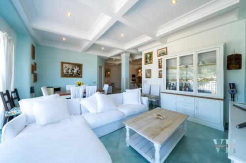 a living room with a white couch and a table at Victory's Luxury House with Jacuzzi on the Roof in Ischia