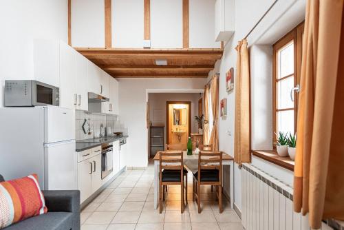 a small kitchen and dining room with a table and chairs at Schrotthof in Feldthurns