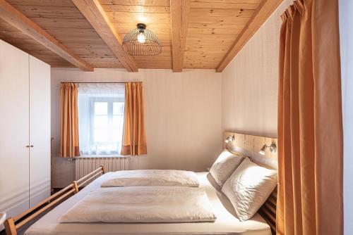a bedroom with two beds and a wooden ceiling at Schrotthof in Feldthurns