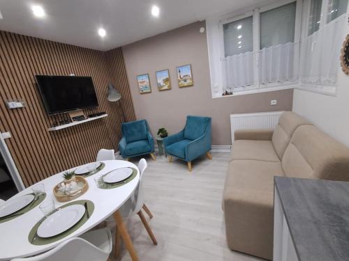 un salon avec un canapé, une table et des chaises dans l'établissement Home Sweet Home, à Calais