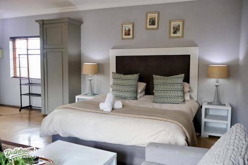 a bedroom with a large bed with green and white pillows at Cherry Grove 3 in Dullstroom