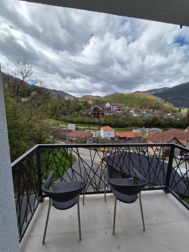 two chairs sitting on a balcony with a view at Apartmani Banjski Biser in Jošanička Banja