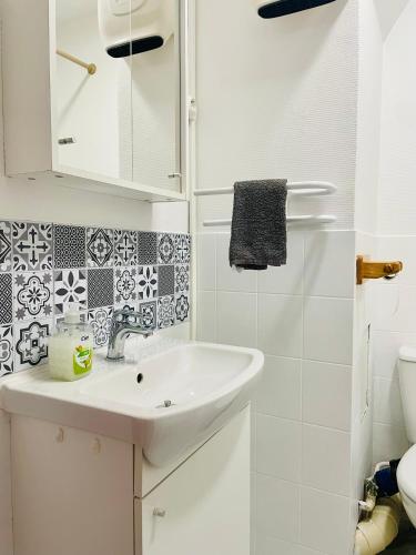 une salle de bain blanche avec un lavabo et des toilettes dans l'établissement L'escale aux 3 frontières, parking, wifi, balcon, à Saint-Avold