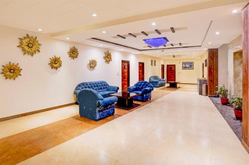 a waiting room with blue chairs and a table at Super Townhouse Prince Chowk Near Railway Station in Dehradun