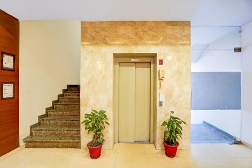 a hallway with two potted plants in front of a door at Super Townhouse Prince Chowk Near Railway Station in Dehradun