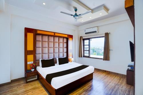 a bedroom with a large bed and a window at Super Townhouse Prince Chowk Near Railway Station in Dehradun