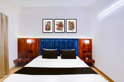 a bedroom with a bed with four pictures on the wall at Super Townhouse Prince Chowk Near Railway Station in Dehradun