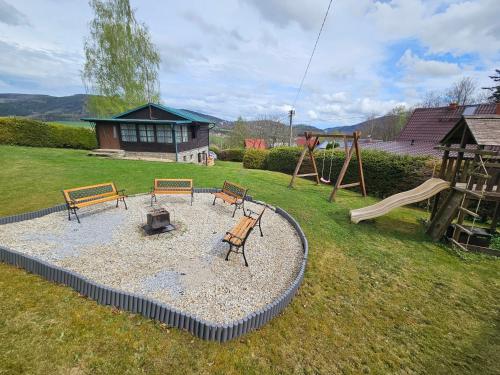 a park with benches and a playground with a slide at Chata Zelenka na Bobrovníku in Lipova Lazne
