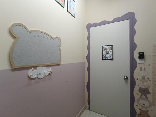 un baño con una puerta con un cartel de ratón ratón en la pared en D1302 Ayesha Homestay D'Alanis 3R2B, en Sepang