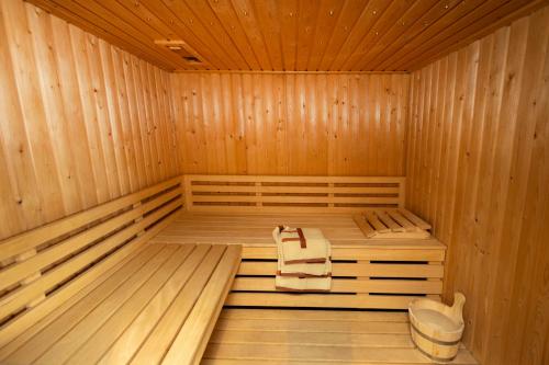 a wooden sauna with two towels and a bucket at Aangenaam op de Rijn, woonboot, inclusief privé sauna in Alphen aan den Rijn