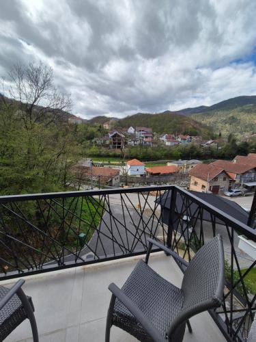 a balcony with two chairs and a view of a town at Apartmani Banjski Biser in Jošanička Banja