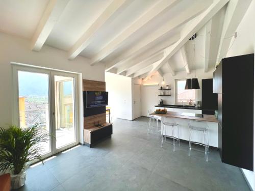 a kitchen with a table and chairs in a room at Attico del Lago - Levico in Levico Terme