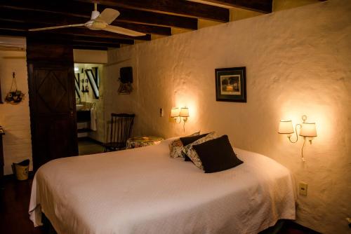 1 dormitorio con 1 cama blanca grande y 2 almohadas en Estancia La Paz casa de campo, en Paysandú