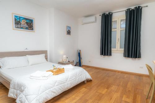 a bedroom with a large white bed with black curtains at Affittacamere - Il Vicoletto in Porto Torres