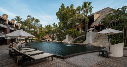 a swimming pool with lounge chairs and umbrellas at The Dewa Koh Chang in Ko Chang