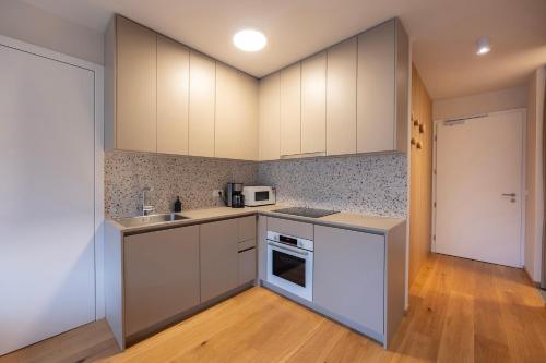 an empty kitchen with white cabinets and a sink at Apartments Alpine Nest in Kranjska Gora