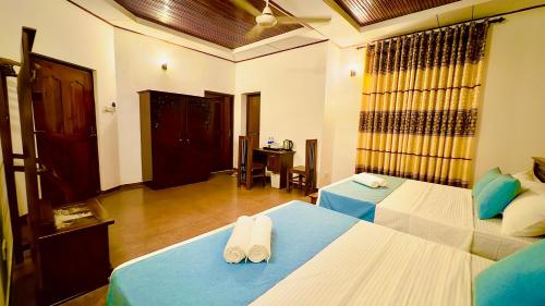 a large room with two beds and a desk at Yahana Beach Villa in Negombo