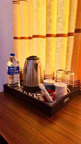 a tray with a tea kettle and other items on a table at Yahana Beach Villa in Negombo