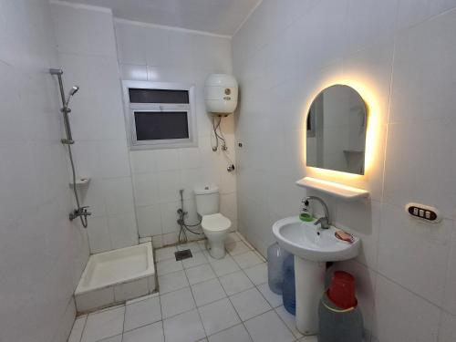 ein weißes Badezimmer mit Waschbecken und Toilette in der Unterkunft Doblex Beach Chalet with Private Garden in Reem ElFala Resort in El-Alamein