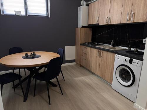 a kitchen with a table and a washing machine at Studio Magheru Residence in Craiova