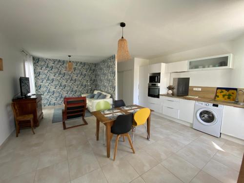 une cuisine et un salon avec une table et des chaises dans l'établissement Appartement à 200 m de l'océan de Capbreton, à Capbreton